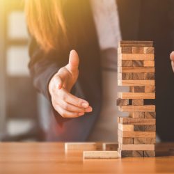 Woman's hand stacking wooden blocks  on a tower,. Business Planning,risk, strategy,development and Alternative risk concept.